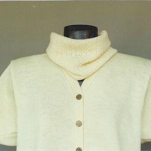 May include: A white knitted sweater with a high collar and short sleeves. The sweater has a button-up front and is made of a soft, lightweight material.