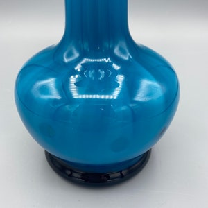 Puede incluir: Un jarr&oacute;n de vidrio azul alto y redondo, con una base azul oscuro. El jarr&oacute;n tiene un acabado brillante y un patr&oacute;n sutil.