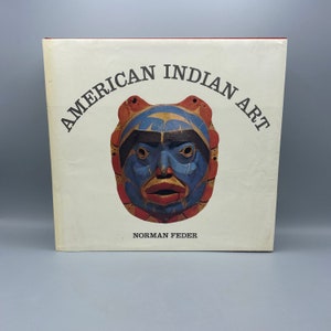 Może przedstawiać: Książka zatytułowana "American Indian Art" autorstwa Normana Feder. Okładka przedstawia kolorową drewnianą maskę pomalowaną na niebiesko, czerwono i czarno.