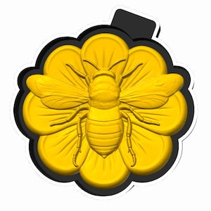 May include: A golden bee pendant with detailed wings and body, centered on a yellow flower with multiple petals. The flower and bee are outlined in black, with a black loop at the top.