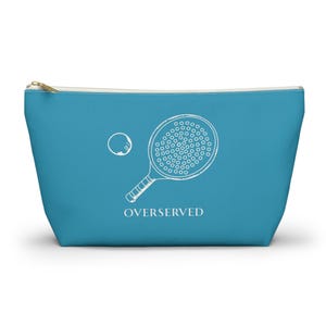 May include: A blue zippered pouch with a white outline of a paddleball racket and ball. The text "OVERSERVED" is printed below the image.