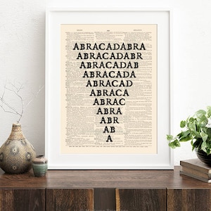 May include: A black and white print of the word "ABRACADABRA" repeated in descending order, printed on a vintage dictionary page with a white frame.