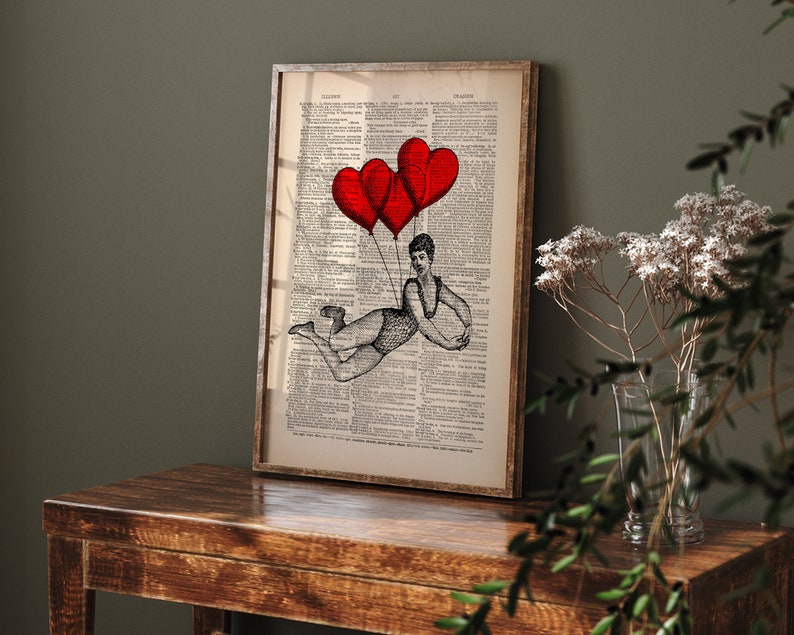 May include: A black and white illustration of a person flying with three red heart-shaped balloons against a vintage dictionary page background.