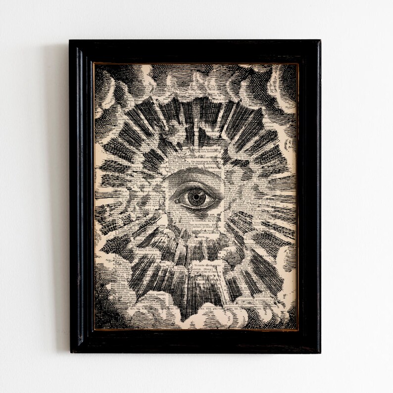 May include: A black and white print of an eye surrounded by a burst of light and clouds. The print is framed in a black frame.