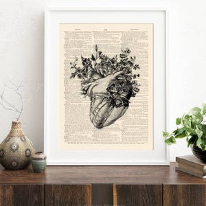 May include: A black and white anatomical heart illustration with flowers growing from it. The image is printed on a vintage dictionary page.