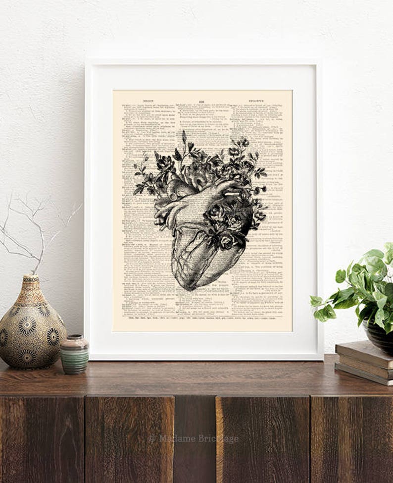 May include: A black and white anatomical heart illustration with flowers growing from it. The image is printed on a vintage dictionary page.
