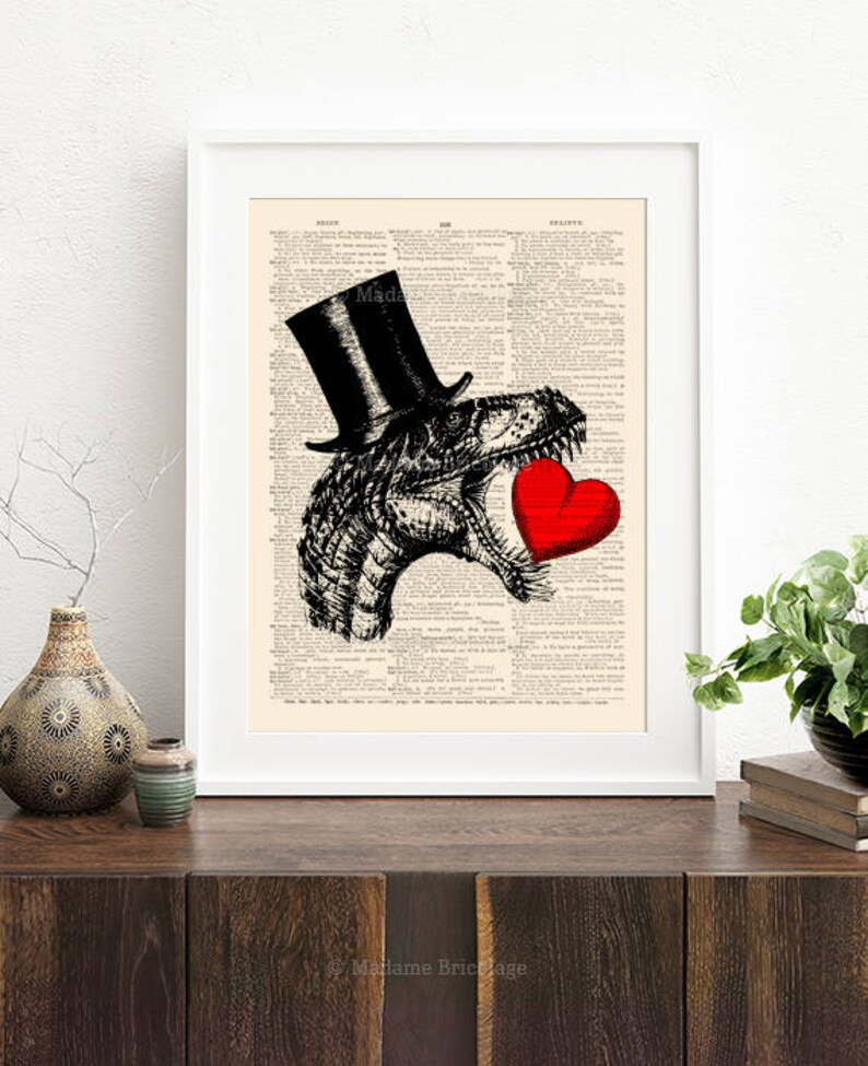 May include: A black and white illustration of a dinosaur wearing a top hat and holding a red heart. The illustration is printed on a vintage dictionary page.