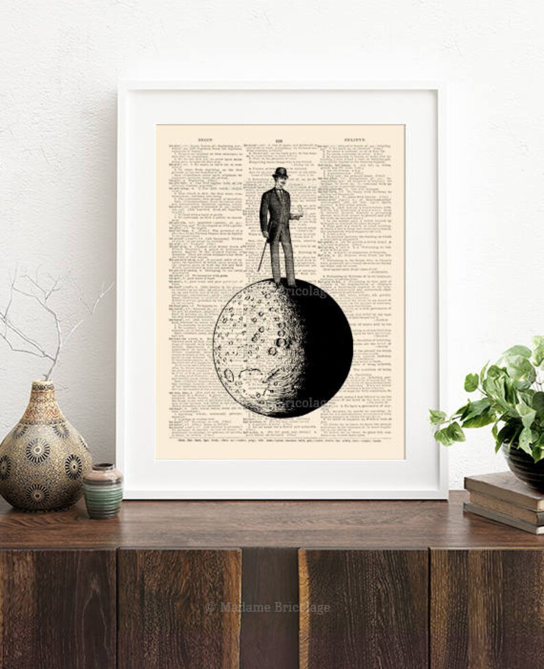May include: A black and white illustration of a man in a top hat standing on the moon. The moon is depicted with craters and a dark side. The illustration is printed on a vintage dictionary page.