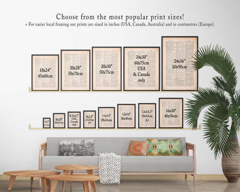 May include: A white wall with a variety of framed prints in different sizes. The prints are all black and white and feature text. The prints are arranged in a grid pattern. The wall is also decorated with a green plant and a couch with pillows.