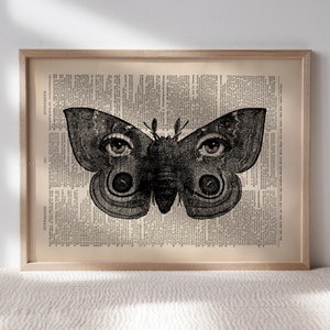 Puede incluir: Una ilustraci&oacute;n en blanco y negro de una mariposa con grandes ojos humanos impresos en una p&aacute;gina de libro vintage.