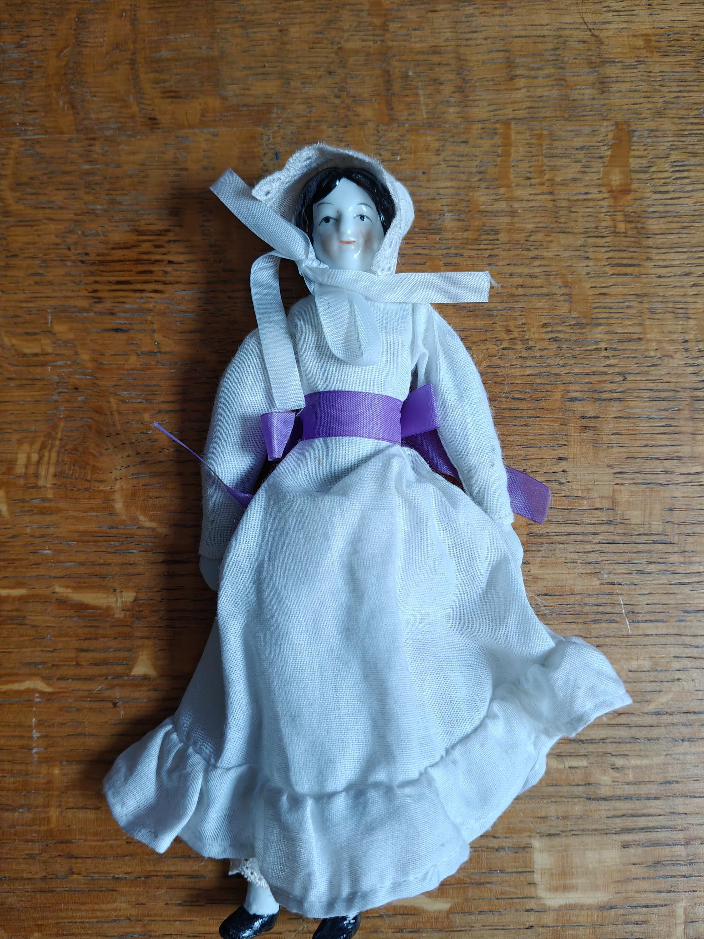 Vintage bone china and cloth doll with purple ribbon and bonet
