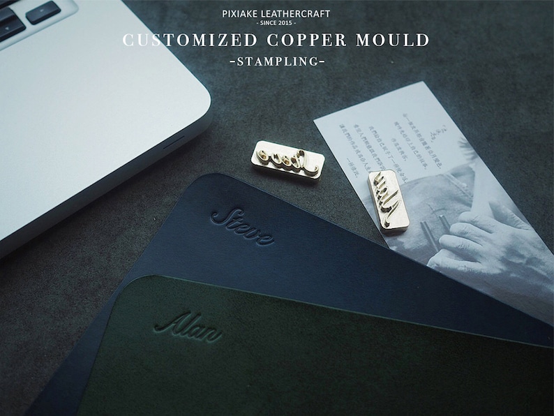 May include: Three custom copper stamps with the names "Steve", "Alan", and "Jill" are shown on top of two leather pads. The leather pads are dark blue and dark green. The text "PIXIAKE LEATHERCRAFT SINCE 2015 CUSTOMIZED COPPER MOULD -STAMPLING- " is visible at the top of the image.