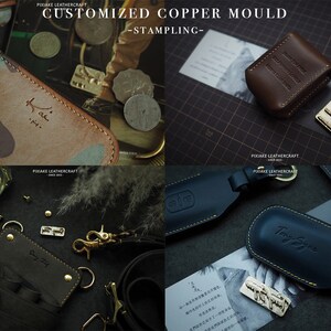 May include: Four different leather goods with custom copper stamping. The items include a camouflage wallet with the name "Kai" stamped on it, a brown leather case with the text "PIXIAKE LEATHERCRAFT" stamped on it, a black leather key chain with the text "Say y" stamped on it, and a blue leather key chain with the text "Tony Syne" stamped on it.