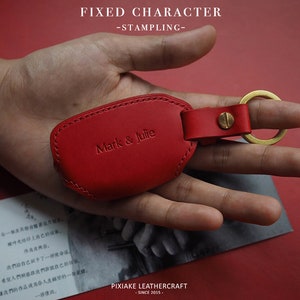May include: Red leather key chain with a gold ring and the text "Mark & Julie" embossed on the front.