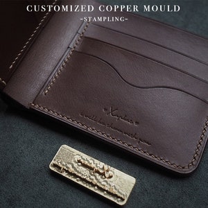 May include: A brown leather wallet with multiple card slots and a stitched edge. The wallet has the text "Xaplaro" and "small is the new big" embossed on the front.