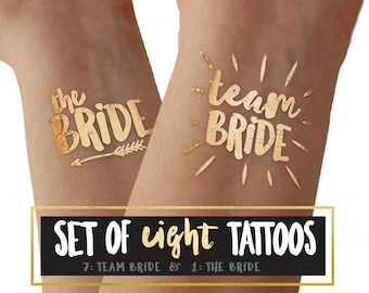 May include: Set of eight gold temporary tattoos, seven with the text "Team Bride" and one with the text "The Bride".