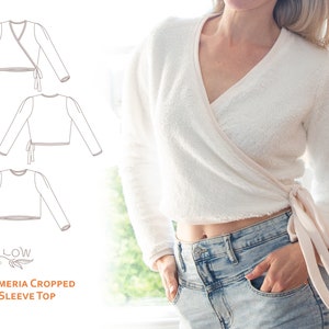 Puede incluir: Un top blanco de manga larga, cruzado y corto, con un lazo en la cintura. El top está hecho de una tela suave y peluda. El texto "The Armeria Cropped Long Sleeve Top" está impreso debajo de la imagen.