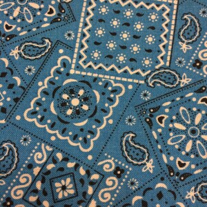 May include: Blue fabric with a white and black paisley pattern. The fabric has a textured surface and is perfect for crafting projects.