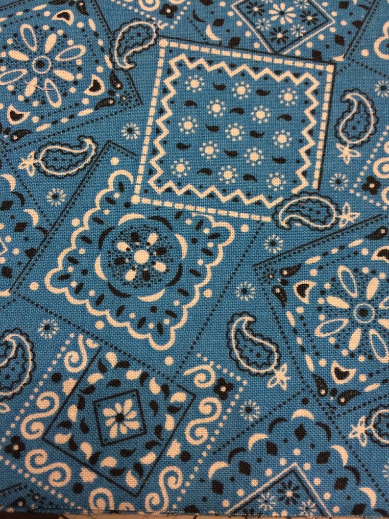 May include: Blue fabric with a white and black paisley pattern. The fabric has a textured surface and is perfect for crafting projects.