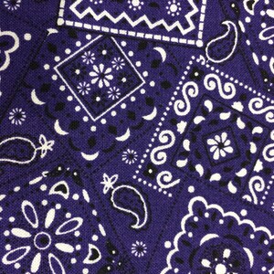 May include: Purple fabric with a white paisley pattern. The fabric has a textured surface and is made of cotton.