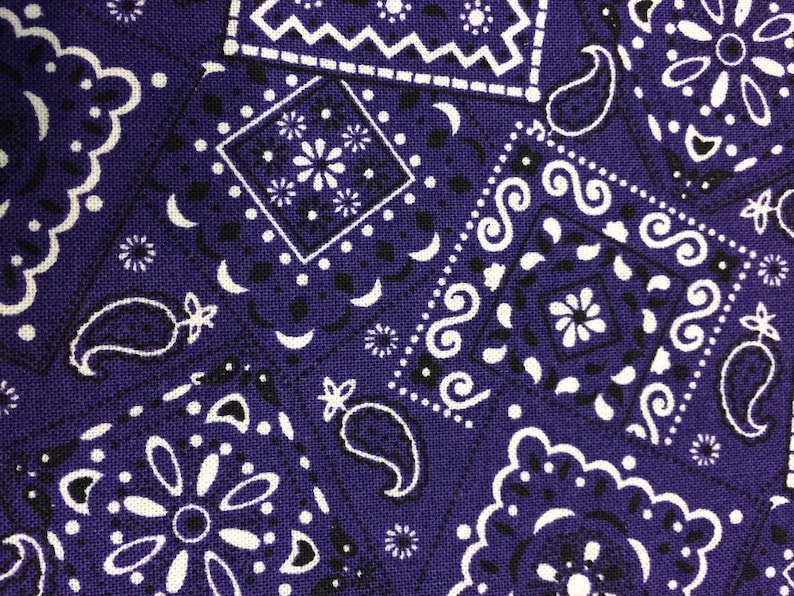 May include: Purple fabric with a white paisley pattern. The fabric has a textured surface and is made of cotton.