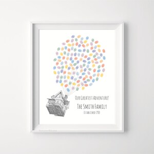 Puede incluir: Impresi&oacute;n enmarcada con una ilustraci&oacute;n de una casa y globos de huellas dactilares de colores. El texto dice "Our Greatest Adventure! The Smith Family Established 1980." La obra de arte est&aacute; enmarcada en un borde blanco.