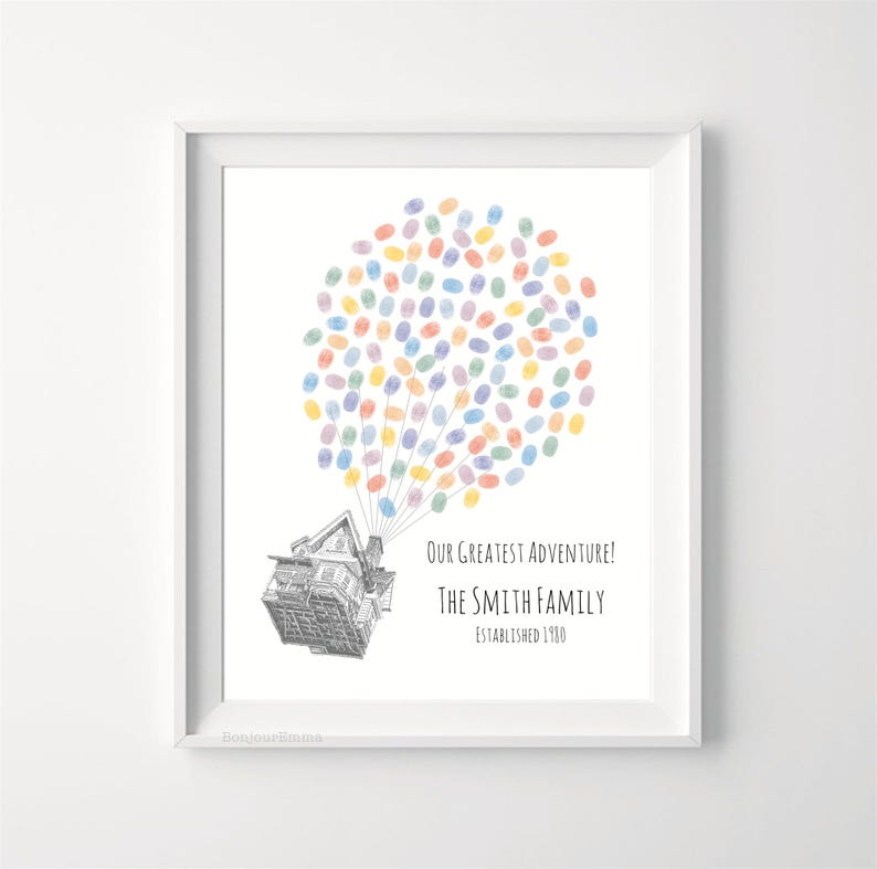 Puede incluir: Impresi&oacute;n enmarcada con una ilustraci&oacute;n de una casa y globos de huellas dactilares de colores. El texto dice "Our Greatest Adventure! The Smith Family Established 1980." La obra de arte est&aacute; enmarcada en un borde blanco.