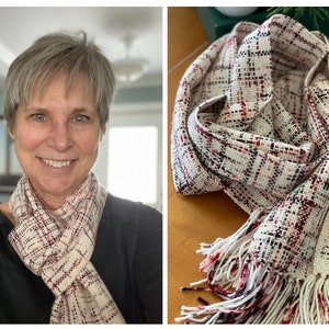 May include: A cream-colored woven scarf with a plaid pattern in red and black. The scarf has a fringed edge. The scarf is wrapped around a person's neck in one image and displayed on a surface in another image.