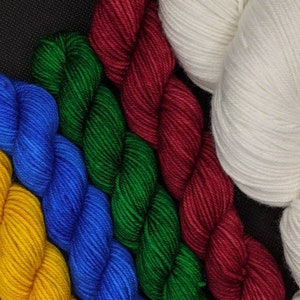 Puede incluir: Cinco ovillos de hilo de diferentes colores: amarillo, azul, verde, rojo y blanco. El hilo est&aacute; dispuesto en forma de abanico.