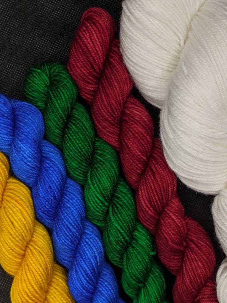 Puede incluir: Cinco ovillos de hilo de diferentes colores: amarillo, azul, verde, rojo y blanco. El hilo est&aacute; dispuesto en forma de abanico.