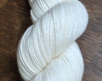 May include: A skein of white yarn, a soft and fluffy material for knitting or crocheting.