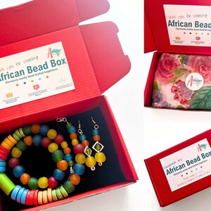 The rainbow beaded jewellery set all packaged up ready to go. The necklace, bracelet and earrings are packed in a bright red box with colourful branded stickers on the inside and outside of the box. The jewellery is wrapped in floral tissue paper.