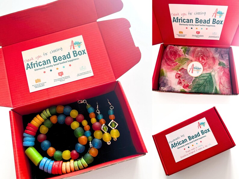 The rainbow beaded jewellery set all packaged up ready to go. The necklace, bracelet and earrings are packed in a bright red box with colourful branded stickers on the inside and outside of the box. The jewellery is wrapped in floral tissue paper.