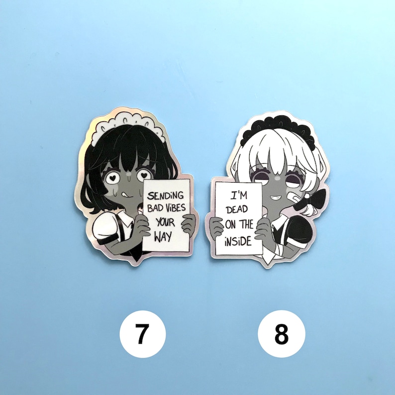 May include: Two black and white stickers of anime characters dressed as maids. The character on the left is holding a sign that says "Sending bad vibes your way". The character on the right is holding a sign that says "I'm dead on the inside".