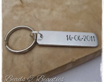 May include: Silver keychain with a silver tag engraved with the date "14.06.2011".