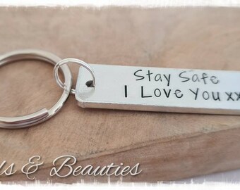 May include: Silver keychain with a silver ring and a rectangular tag that says "Stay Safe I Love You xx".