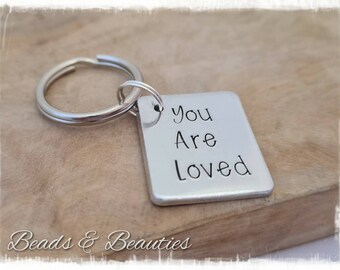 May include: Silver keychain with a small rectangular tag that reads "you are loved".