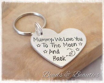 May include: Silver heart-shaped keychain with the text "Mummy, We Love You To The Moon And Back" engraved on it. The keychain features a crescent moon and stars.