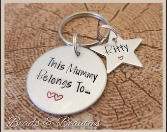 May include: Silver keychain with a round tag that says "This Mummy Belongs To..." with two red hearts and a star-shaped tag that says "Kitty" with a red heart.