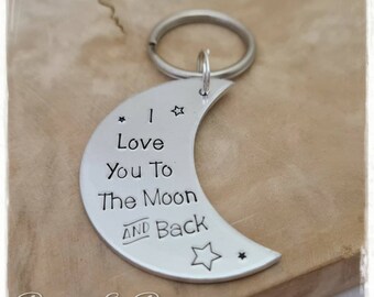May include: Silver crescent moon keychain with the text "I love you to the moon and back" and two small stars.