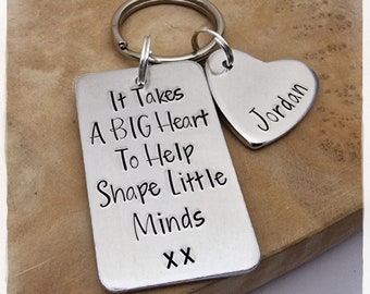 May include: Silver keychain with a rectangular tag that reads "It Takes A BIG Heart To Help Shape Little Minds XX" and a heart-shaped tag that reads "Jordan".