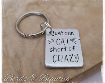 May include: Silver keychain with a square tag that reads "Just one CAT short of CRAZY".