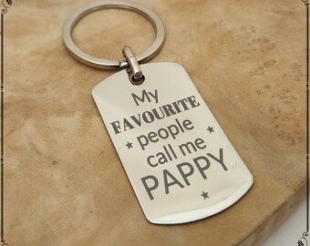 May include: A silver-colored keychain with a rectangular tag. The tag is engraved with the words "My FAVOURITE people call me PAPPY" in a bold, sans-serif font. The keychain has a circular ring.