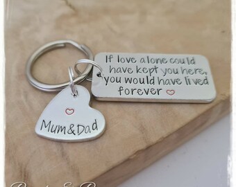May include: Silver keychain with a heart-shaped charm that says "Mum & Dad" and a rectangular charm that says "If love alone could have kept you here, you would have lived forever".