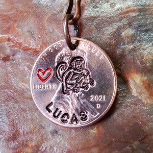 May include: A copper-colored keychain with a US penny featuring a monkey and the words "In God We Trust", "Liberty", and "2021". The penny also has a red heart and the name "Lucas" engraved on it.