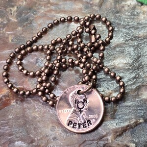 Puede incluir: Un collar de cobre con una cadena de bolas. El centavo ha sido grabado con el nombre "Peter" y el a&ntilde;o "2005".