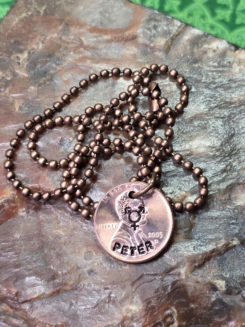 Puede incluir: Un collar de cobre con una cadena de bolas. El centavo ha sido grabado con el nombre "Peter" y el a&ntilde;o "2005".