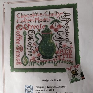 May include: Cross-stitch pattern titled "Summer Buzz" featuring a green coffee pot, cherries, and various coffee-related words like "Chocolate," "Creole," and "Espresso." Design size is 98 x 99 stitches. Designed by Deborah A. Dick.