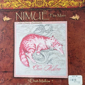 May include: Cross-stitch pattern featuring a pink cat sleeping on a bed of clouds. The pattern is titled "Chat-Mallow" and is part of the "Les Chats Enchantes" collection by NIMUE Fée Main.