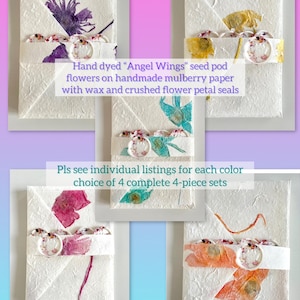 May include: Four handmade paper envelopes with pressed flowers and wax seals. The envelopes are hand-dyed in shades of purple, blue, pink, and orange. The text reads "Hand dyed 'Angel Wings' seed pod flowers on handmade mulberry paper with wax and crushed flower petal seals. Pls see individual listings for each color choice of 4 complete 4-piece sets."